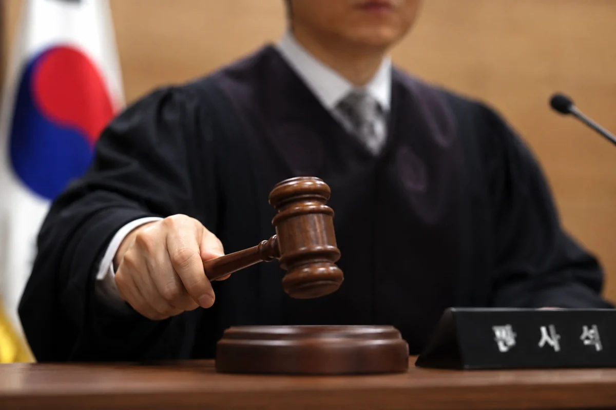 전주 무단횡단 사고 운전자 과실|법정에서 의사봉을 든 판사와 판사석 명패